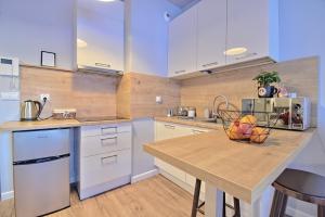 a kitchen with a table with a basket of fruit on it at Miejsko Tu - Opera #134 in Olsztyn