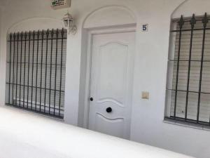 a white door in a room with two windows at Apartamento en La Almadraba in Chiclana de la Frontera +4 photos