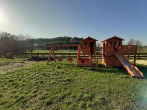 un parque infantil al aire libre con tobogán en Zalesie - wyjątkowe domki nad jeziorem, en Zalesie