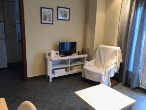 a living room with a tv and a chair at Apartamento en La Almadraba in Chiclana de la Frontera