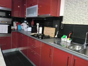 a kitchen with red cabinets and a stove and a sink at Retiro da Estrela in Seia