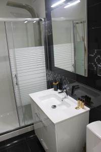 uma casa de banho com um lavatório branco e um chuveiro em Duque de Loulé - Apartments - Apartamento D em São Martinho do Porto