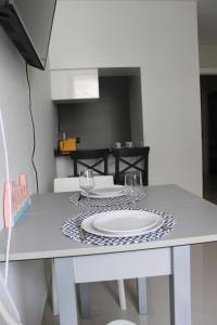 a table with a plate and two glasses on it at Duque de Loulé - Apartments - Apartamento D in São Martinho do Porto