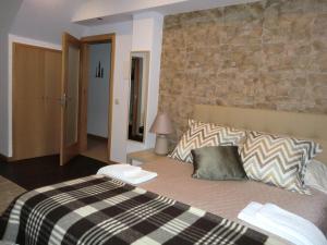 a bedroom with a large bed with a stone wall at Retiro da Estrela in Seia