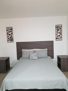 a bedroom with a white bed and two night stands at Sea Rock Hotel in Puerto Peñasco