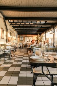 a restaurant with a checkered floor and tables and chairs at Hotel Hirschen am See in Meilen