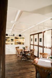 فندق Hirschen am See في ميلين: غرفة طعام مع طاولات وكراسي خشبية
