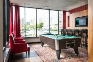 a billiard room with a pool table and a red chair at Bastion Hotel Den Haag Rijswijk in Rijswijk