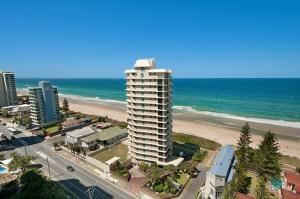 a tall building on the beach next to the ocean at Beachside Tower Apartments in Gold Coast