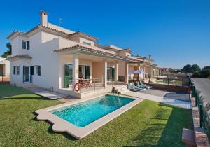 uma villa com piscina em frente a uma casa em Villa Marisa I em Alcudia