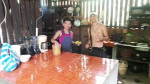 twee mannen staan in een keuken met een tafel bij Hostal La Gloria in Mérida