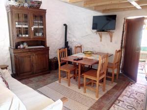 a dining room with a table and chairs and a tv at REFÚGIO DO RAPOSO/CASA DENEB (CC) in Montes da Senhora