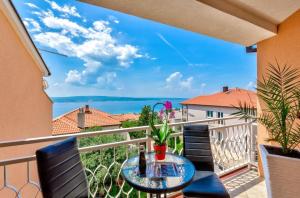 a balcony with a table and chairs and a view of the ocean at Apartment in Crikvenica 27606 in Crikvenica
