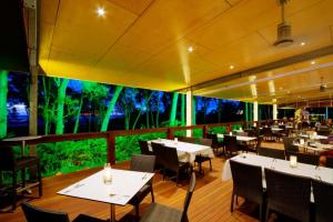 un restaurant avec des tables et des chaises et un mur végétal dans l'établissement Albatross Bay Resort, à Weipa
