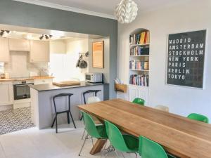 a kitchen with a wooden table and green chairs at 21 British Road in St. Agnes