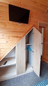 a room with a bed with a tv in a wooden ceiling at Agroturystyka u Jarka in Bryzgiel
