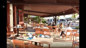 a group of people sitting at tables in a restaurant at Ti-Colibris in Saint-François