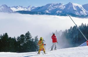 2 personnes à skis sur une montagne enneigée dans l'établissement Village Vacances Le Tarbesou, à Ax-les-Thermes