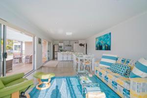 een woonkamer met een bank en een keuken bij Rose's Beach Pad - Matarangi Holiday Home in Matarangi