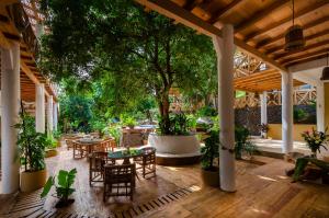 un patio extérieur avec des tables, des chaises et un arbre dans l'établissement Carpe Diem Casitas & Villas Mazunte, à Mazunte