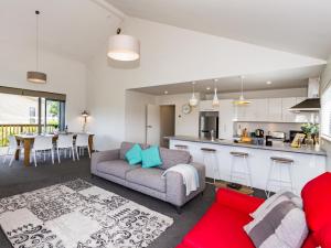 a living room with a couch and a kitchen at Kanuka Kalm - Ohakune Holiday Home in Ohakune