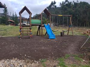 a playground with a slide and a swing at La Casona Cucaita. Sede Campestre in Cucaita