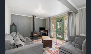 a living room with a couch and a fireplace at Cozy Stay Cottage in Daylesford