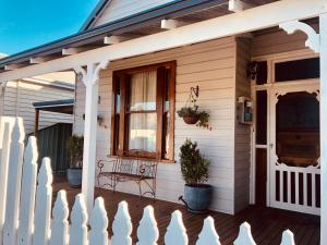 a porch of a house with a bench and a window at Railway Cottage in Bunbury