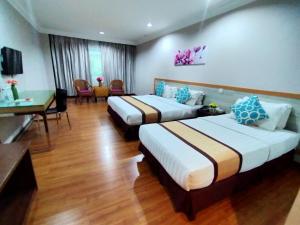Habitación de hotel con 2 camas y escritorio en TD Plaza Hotel, en Kota Kinabalu
