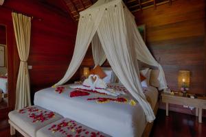 Un dormitorio con una cama con flores. en Ubud Padi Villas en Ubud