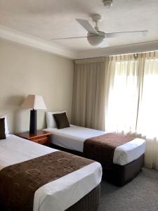 A bed or beds in a room at Bougainvillea Gold Coast Holiday Apartments