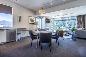 a dining room and living room with a table and chairs at The Aerie in Queenstown