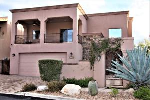 a pink house with a garage and a cactus at Your Home Away From Home in Tucson