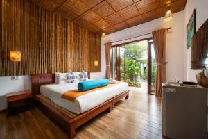 ein Schlafzimmer mit einem Bett und einem großen Fenster in der Unterkunft An Bang Gold Coast Beach Villa in Hoi An