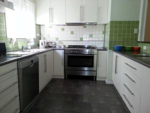 a kitchen with white cabinets and a black oven at HEALESVILLE GETAWAY in Healesville