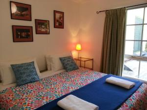 una camera da letto con un grande letto con cuscini e una finestra di HEALESVILLE GETAWAY a Healesville