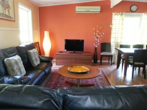 a living room with a leather couch and a table at HEALESVILLE GETAWAY in Healesville
