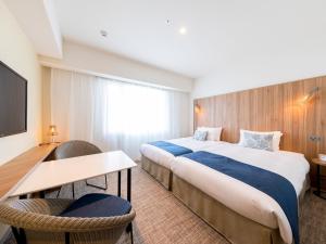 um quarto de hotel com duas camas e uma secretária em Tokyu Stay Okinawa Naha em Naha