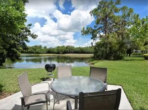 um pátio com uma mesa e cadeiras e um lago em Florida Vacation Condo em Sarasota