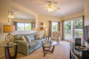 a living room with a couch and a tv at 202-S - Sunset Vistas in St. Pete Beach