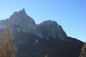 Une grande montagne avec des arbres devant elle dans l'établissement Villa Anna, à Alpe di Siusi