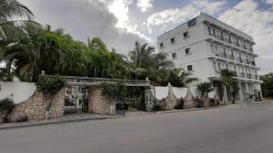 a large white building with palm trees on the side of a street at Mansion Giahn Bed & Breakfast in Cancún