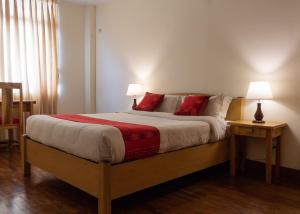 a bedroom with a large bed with red pillows at ROKPA Guest House in Kathmandu