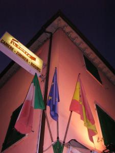 un groupe de parapluies sur le côté d'un bâtiment dans l'établissement Il Ponte Affittacamere, à Lucques