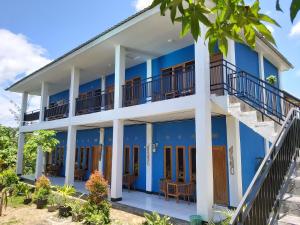 a blue and white building with a balcony at Danke Lodge in Labuan Bajo