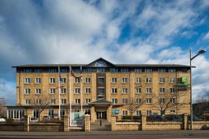 un gran edificio de ladrillo con un cartel delante en Holiday Inn Express Edinburgh - Leith Waterfront, an IHG Hotel, en Edimburgo