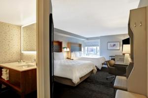 um quarto de hotel com duas camas e um lavatório em Holiday Inn - Ottawa Dwtn - Parliament Hill, an IHG Hotel em Ottawa