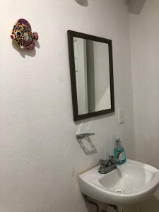 ein Badezimmer mit Waschbecken und Spiegel an der Wand in der Unterkunft Marina Diamante in Acapulco