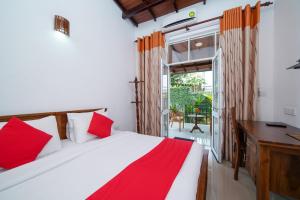 1 dormitorio con cama, escritorio y ventana en Dazzling Villa en Kandy