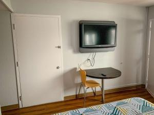 um quarto com uma mesa e uma televisão na parede em Motel 6-Dayton, OH em Dayton